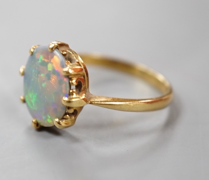 A modern 18ct gold and oval black opal set ring, size P/Q, gross weight 3.6 grams.